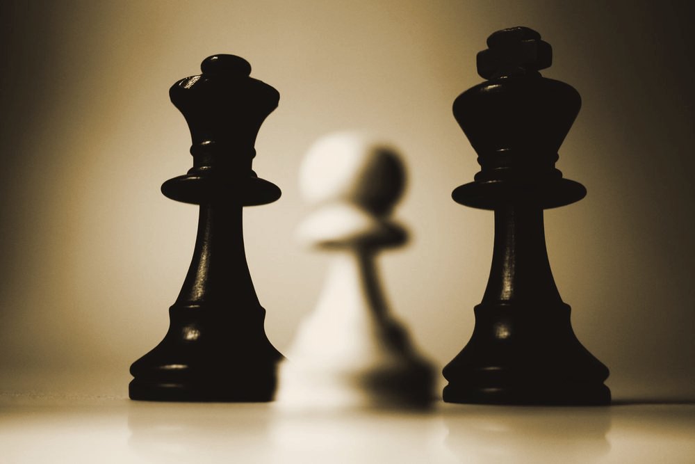 Chess kings facing each other in dramatic side lighting