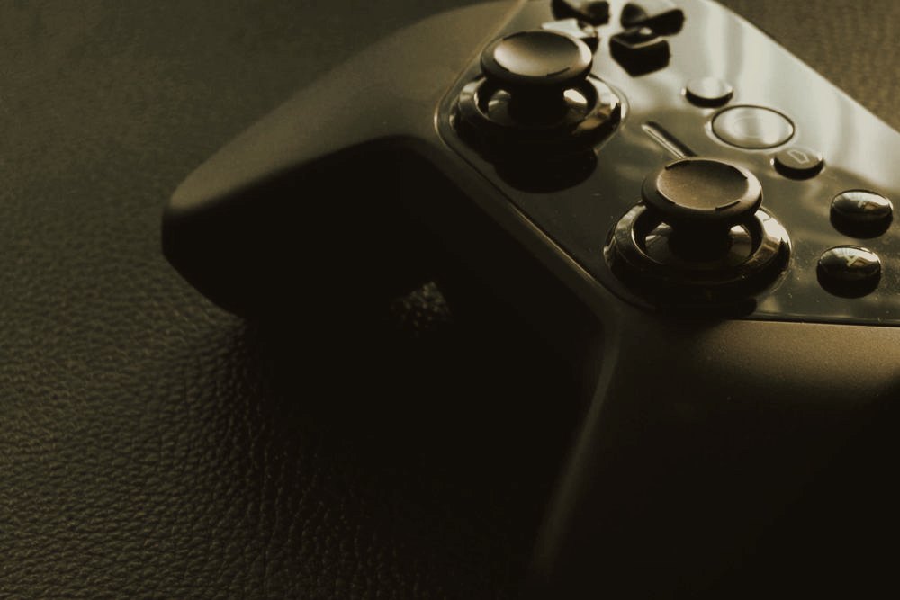 A game controller resting on a dark surface in low moody light